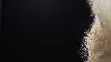 Beyaz toz, şefin hazırladığı siyah arka plana karşı nefis bir akşam yemeği için kumaştan sekiyor.