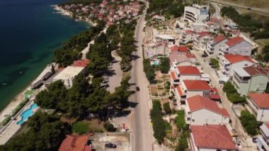 Hırvatistan 'da güneşli bir günde, adanın kıyı manzarası, maliyet ve küçük yazlık boyunca uzanan uzun bir sokak manzarası