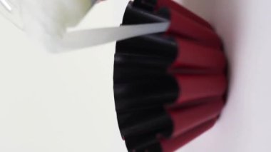 Beyaz arkaplana karşı dönen bir fırın çanağına hamur dökmek