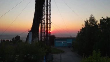 Eski paslı sıçrama tahtasının drone görüntüsü ve bulutlu gökyüzünün altındaki yeşil ağaçlar nehrin yanında gün doğumunda