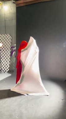 Yumuşak ışıklandırma ve akışkan kumaşlarla çevrili bir bale stüdyosunda zarif bir rutinle göz kamaştıran bir dansçı..