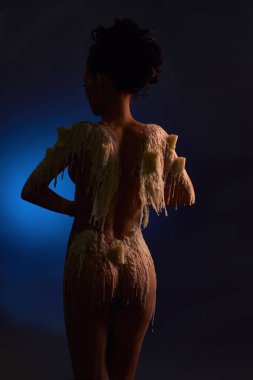 Erimiş mumları ve çıplak bedenini karanlıkla kaplayan çıplak kadın modelinin arka plan görüntüsü