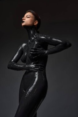 Boynuna kadar kirlenmiş çıplak genç bir kadın karanlık odada derin nefes almaya çalışıyor.