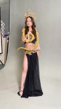 Bir kadın, büyüleyici göbek dansını sergiliyor ve bir yılanın yer aldığı süslü bir kostüm giyiyor..