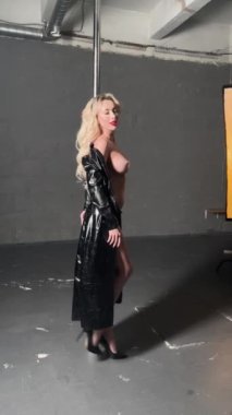 İç çamaşırı ve vücut sanatı içinde çarpıcı bir kadın bir direkle zarif bir şekilde etkileşime girer ve güzelliğini gösterir..