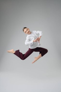 Genç bir kız neşeyle dans ediyor, atletizmini ve sanatını stüdyoda gösteriyor..