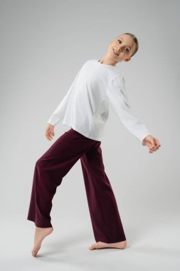 Genç kız gündelik kıyafetleriyle zarif bir şekilde dans ediyor, atletizm ve sanat tutkusunu sergiliyor..