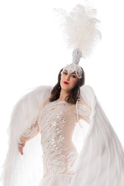 A performer showcases an elaborate costume with feathers and sequins, exuding confidence in an artistic presentation. clipart