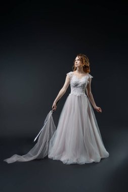 Gelin gibi giyinmiş çarpıcı bir kadın yumuşak kumaşlı, rüya gibi bir gecelikle zarafet sergiliyor..