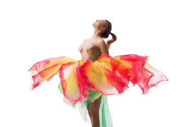 Bir dansçı renkli akıcı kumaş giyerken dinamik hareketler sergiler, temiz beyaz bir arkaplan karşısında büyüleyici bir görüntü yaratır.