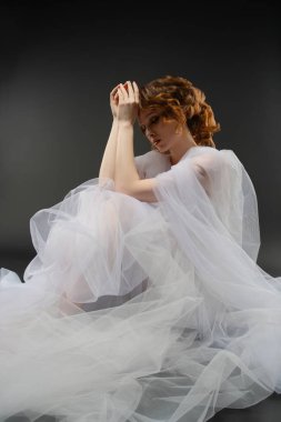 Zarif bir kadın narin iç çamaşırlarıyla poz verir. Yumuşak tülle kaplanır. Güzelliği ve zarafeti somutlaştırır..