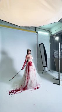 Çarpıcı gelinlik giymiş bir kadın sahne arkasında dramatik efektleri olan sanatsal ve cesur bir estetik sergiliyor..