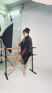 Bir kadın, bir dans stüdyosunda sahne arkasında üstsüz poz verir. Gösteriden önce zarafetini ve esnekliğini vurgular..