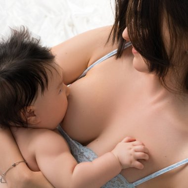 Bir anne, bebeğini sevgiyle sıcak ve samimi bir ortamda emzirir. Yakın bağlarını ve beslenme anlarını gösterir..