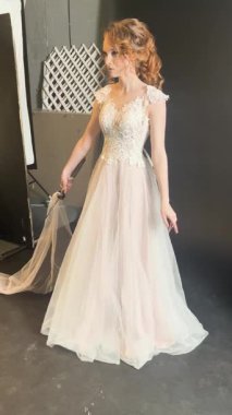 Güzel elbiseli bir gelin sahne arkasında poz verir. Özel günü için zarafet ve heyecan saçar..