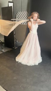 Gelin gibi giyinmiş bir kadın tören başlamadan önce sahne arkasında eşsiz bir dekor ile poz verirken güzelliğini sergiliyor..