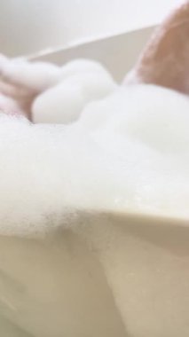 Bir kadın, üstsüz ve sükunetle çevrili bir otel odasında dinlenmenin tadını çıkarır..