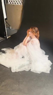 Bir gelin zarif bir şekilde sahne arkasında bekler, zarif bir gelinlik içinde, güzel ve zarif bir şekilde..