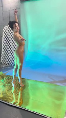 Bir kadın dans figürlerini yaratıcı ve canlı bir stüdyo ortamında sergiliyor. Kendine güven ve zarafet saçıyor..