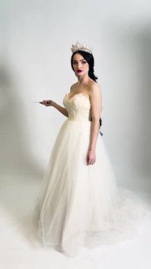 Bir gelin özel gününe hazırlanıyor. Zarif bir makyaj ve sahne arkasında göz kamaştırıcı bir elbise sergiliyor..