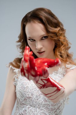 Gelinlik giymiş bir kadın elinde bir katana, elinde kan, ateşli bir güzellik ve gizem saçar..