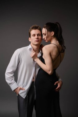 Bir çift samimi bir kucaklaşmayı paylaşıyor. Kadın zarif iç çamaşırlarıyla, adam şık bir tişörtle kimyalarını sergiliyor..