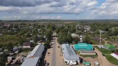 Bulutlu gökyüzünün altındaki yeşil ağaçlar, Luza, Kirov Bölgesi ve konut binaları ile şehir manzarası