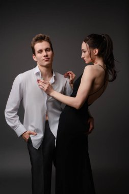 Zarif iç çamaşırlı bir kadın ve gündelik gömlekli bir erkek, ilişkilerini ifade etmek için birlikte eğlenceli bir an paylaşıyorlar..