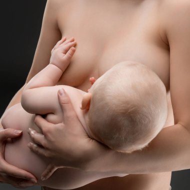 Bir anne yeni doğmuş bebeğini şefkatle emzirirken kapalı bir ortamda rahat bir şekilde oturur, aralarındaki samimiyeti ve sıcaklığı iletir..