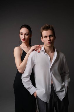 Zarif iç çamaşırlı bir kadın bir erkeğe yakın durur, onların kimyasını ve ilişkilerini ön plana çıkarır..