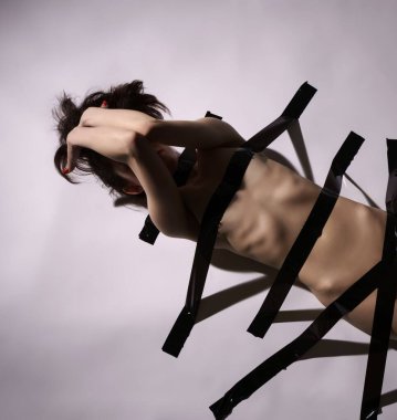 Cinsel kölelik fetiş olarak. Koli bandı ile çıplak kadın