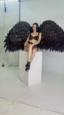 Bir kadın eşsiz kanatları olan bir stüdyoda güzelliğini ve güvenini sergiliyor..