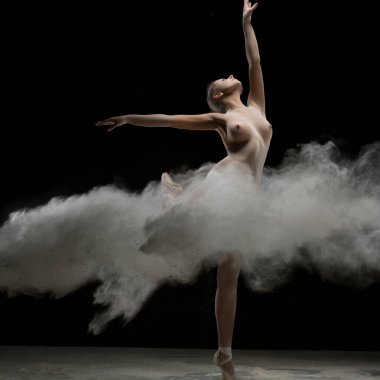 Genç kız pointe içinde beyaz toz bir patlama dans üstsüz siyah duvara vurdu