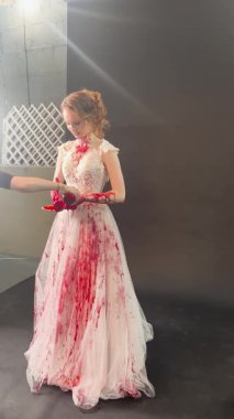 Beyaz elbiseli güzel bir gelin sahne arkasında kan sanatını sergiliyor..