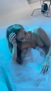 Bir kadın, zarif zarafet ve özgüvenle güzelliğini sergileyerek nefes kesici bir stüdyo ortamında poz verir..