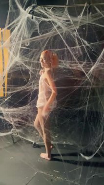 Kırmızılı çarpıcı bir kadın, eşsiz bir düzende güzellik ve yaratıcılığın bir karışımını gösteren uçsuz bucaksız bir ağda geziniyor..