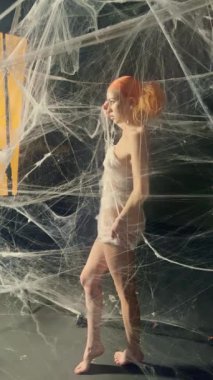 Büyüleyici bir performans yıldızları kızıl saçlı bir kadın zarif bir şekilde dev bir ağa dolanmış, güzellik ve sanatın bir karışımı..