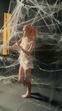 Kızıl saçlı çarpıcı bir kadın samimi bir ortamda ayrıntılı bir ağ arkaplanıyla şakalaşıyor..