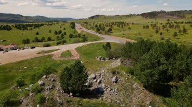 Yuvarlanan tepeler ve yeşil otlaklar, yakınlardaki bir yol boyunca keşif yapmak için ideal sakin bir manzara yaratır..