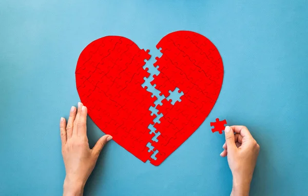Red Puzzle Heart Shape Hands Connect White Details Puzzle Blue — Stock Photo, Image