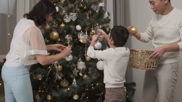 Glad Familie Hængende Dekorative Bolde Til Juletræ Sammen Hjemme – Stock-video