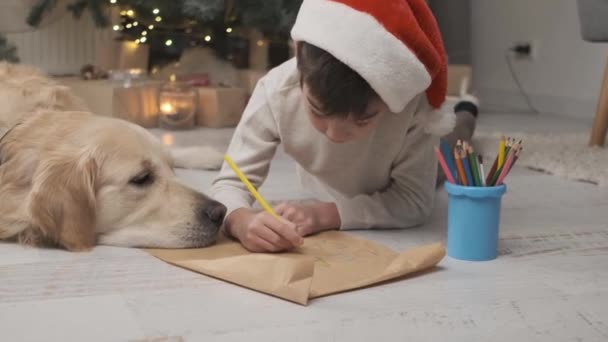 Menino Criança Escrevendo Carta Para Santa Cláusula Enquanto Deitado Lado — Vídeo de Stock