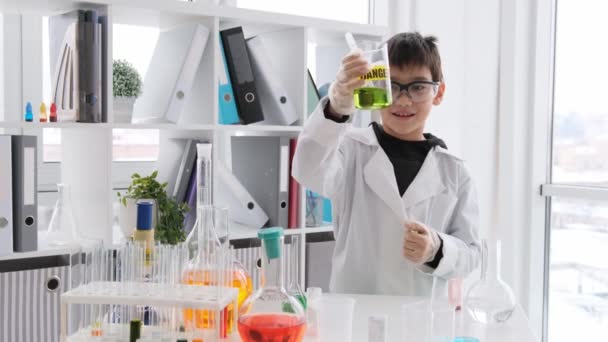 Uczeń Lekcji Chemii Nosi Okulary Ochronne Patrząc Butelkę Zielonym Płynem — Wideo stockowe