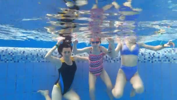 妈妈和她的孩子们在游泳池里游泳 女孩们在水里玩得很开心 — 图库视频影像
