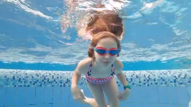 かわいいです女の子とともにゴーグルダイビングとスイミング水中でAプール — ストック動画