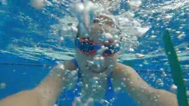 ゴーグルダイビングやプールで水中で泳ぐかわいい女の子 子供は水の中で自撮り — ストック動画