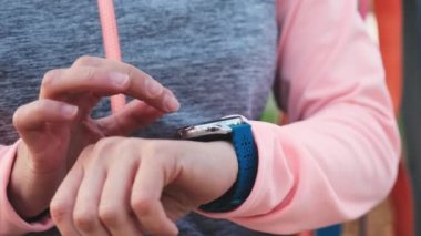 Fitness kızı akıllı saat egzersizlerini kontrol ediyor. Puls izleyicili spor kadın yakın plan.
