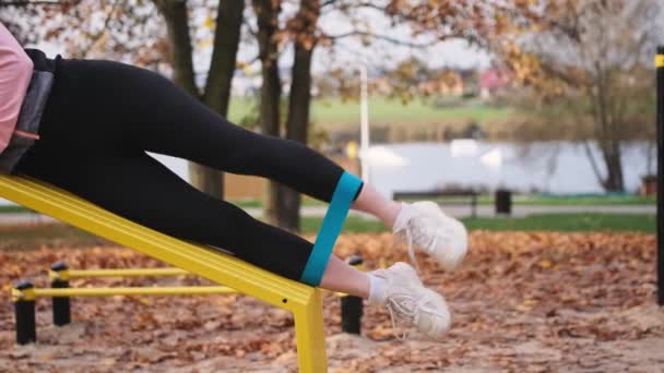 Spor Salonundaki Kız Sonbahar Parkında Lastik Bantla Bacak Egzersizi Yapıyor — Stok video