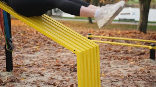 Фітнес Дівчина Робить Відсутність Тренувань Піднімаючи Ноги Вгору Осінньому Парку — стокове відео