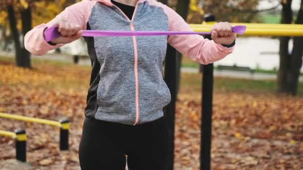 Fitness Dziewczyna Robi Ramiona Klatki Piersiowej Trening Elastyczną Gumką Jesieni — Wideo stockowe